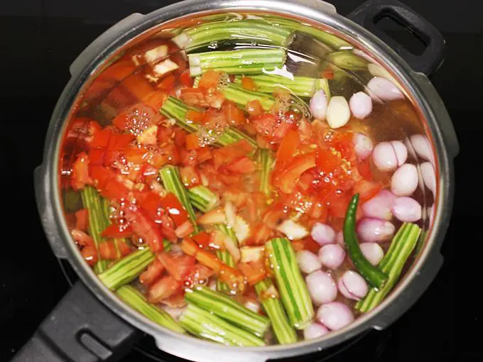 pouring water to make drumstick sambar