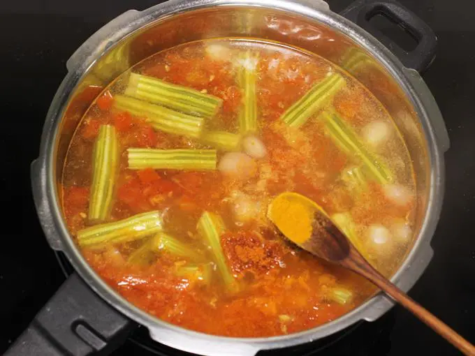 adding turmeric to make drumstick sambar