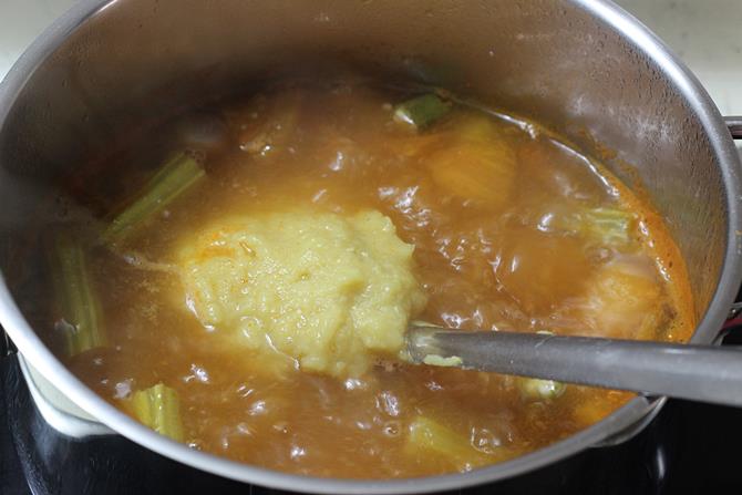 adding cooked mashed dal to pot to for sambar recipe