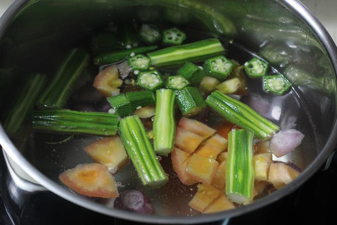 cooking vegetables in a large pot to make sambhar