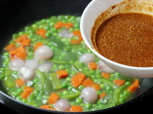 pouring tamarin mixture to make bisi bele bath