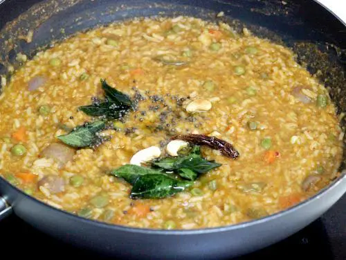 pouring tempering over the bisi bele bath