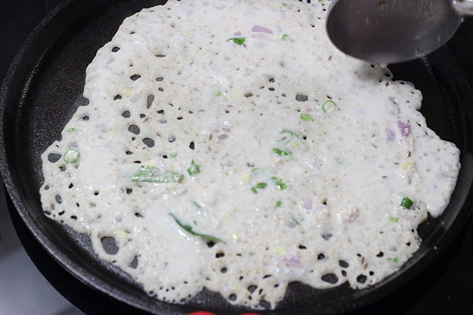 pouring batter to make oats dosa