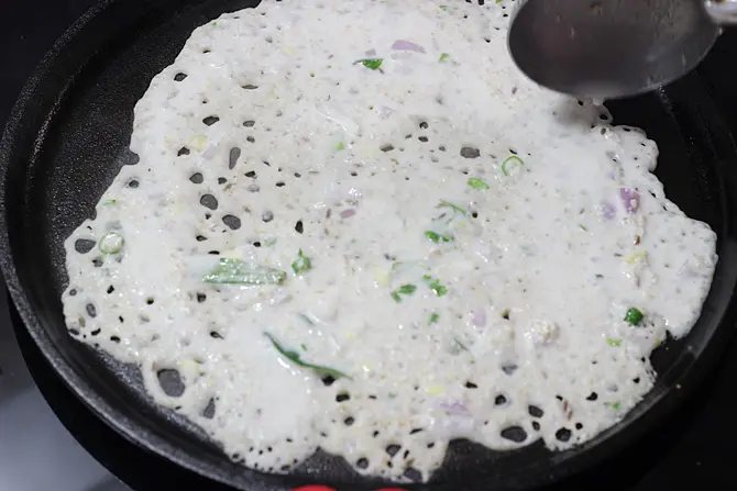 pouring batter to make oats dosa