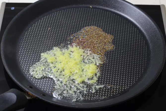 tempering cumin on a tawa for tawa paneer
