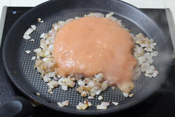 frying tomato puree with onions for tawa paneer