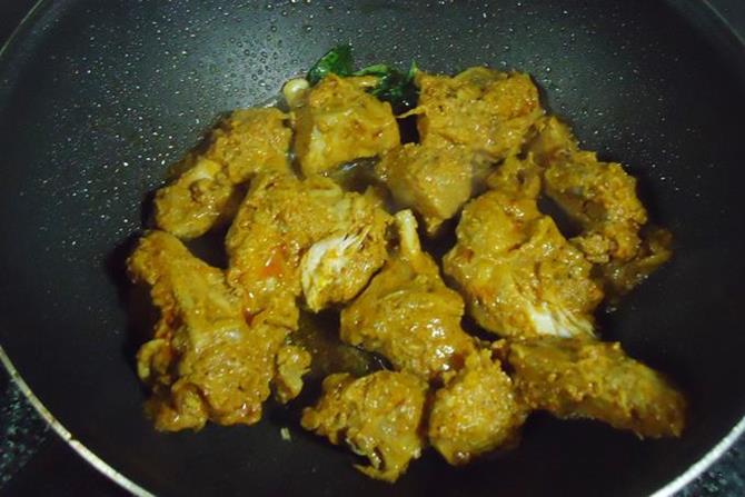 addition of curry to pan for making chicken ghee roast