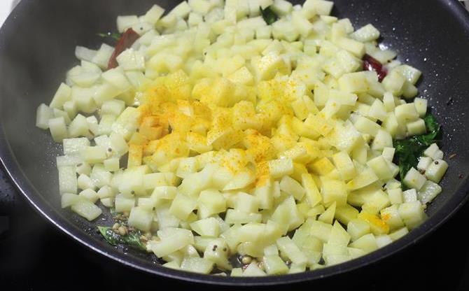 addition of cubed potato to pan for aloo fry recipe