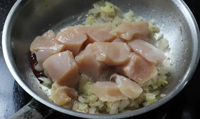addition of chicken to onions to make kadai chicken recipe