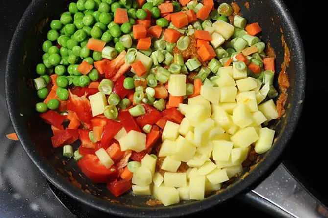 sauteing mixed vegetable curry in pan