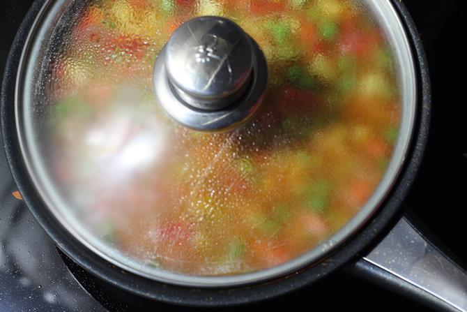 cooking mixed vegetable curry on a low flame