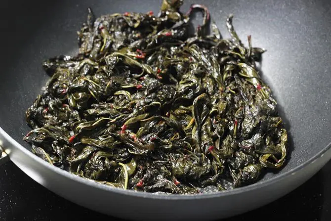 frying leaves until wilted in the pan to make gongura pachadi