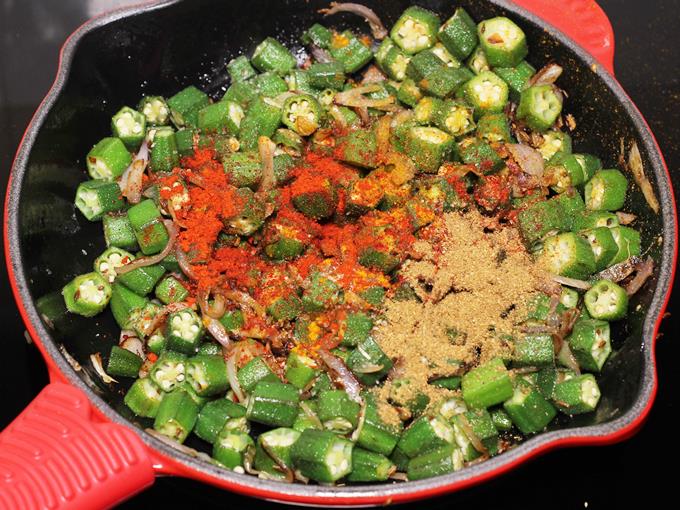 adding spices to bhindi ki sabji