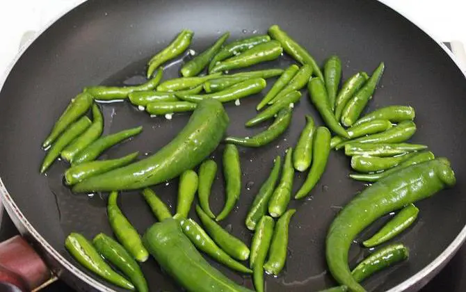 frying chilly in oil to make green chili chutney