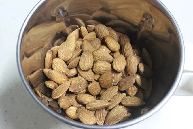 Add almonds and cardamoms to a mixer jar