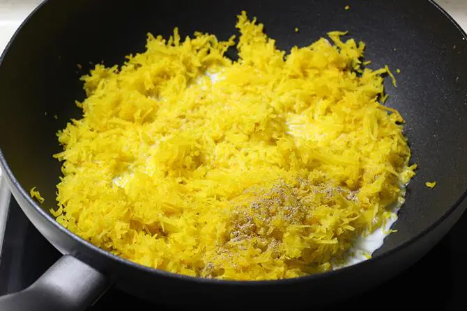 adding milk to pan to cook pumpkin halwa