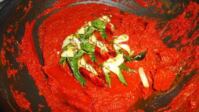 tempering with curry leaves in oil to make tomato achar