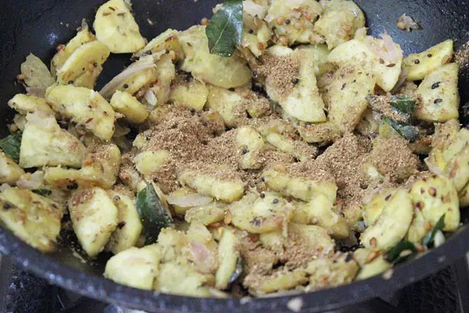 sprinkling garam masala to make raw banana fry