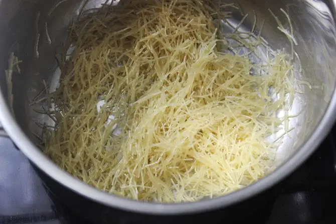 frying vermicelli in ghee to make semiya kesari recipe