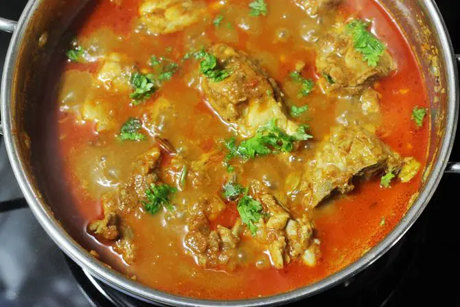 Garnishing chicken curry with coriander leaves