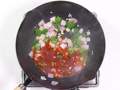 adding chili sauce to the wok