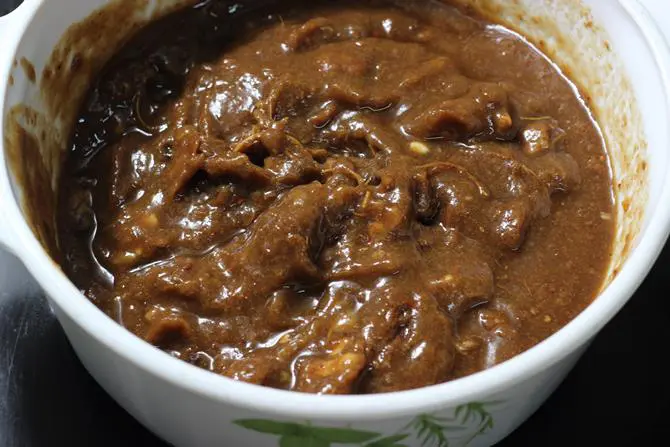 Squeezing soaked pulp to make tamarind paste