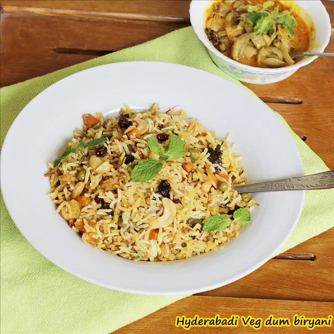 garnished hyderabadi veg biryani with mint and nuts by swasthi