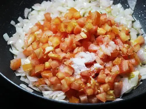 adding tomatoes salt to make paneer butter masala