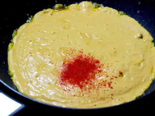 adding puree chili powder to make paneer butter masala gravy
