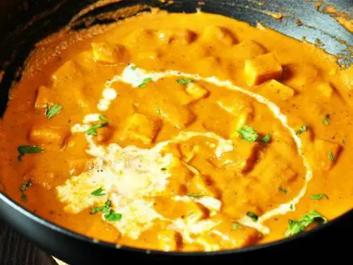 adding cream to paneer butter masala