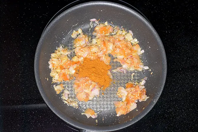 adding spice powders to make tawa pulao