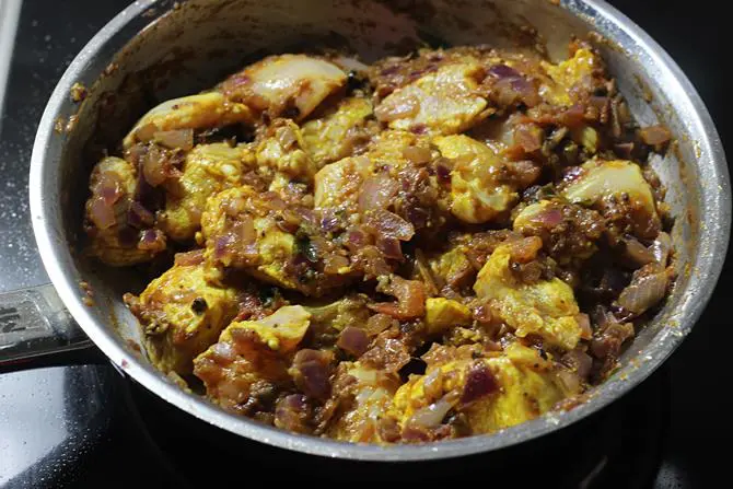 addition of marinated pepper chicken to the pot for frying