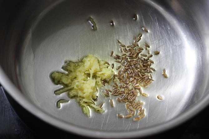 seasoning cumin ginger in ghee for making oats khichdi