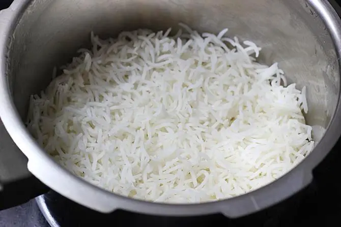 layering cooked rice in a pot for fish biryani recipe