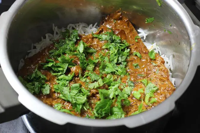 layering biriyani gravy over rice to make hyderabadi fish biryani recipe