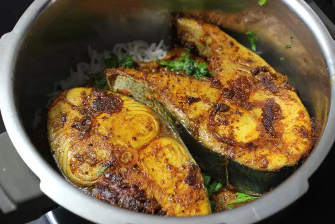 layering fried fish over the gravy for fish dum biryani recipe