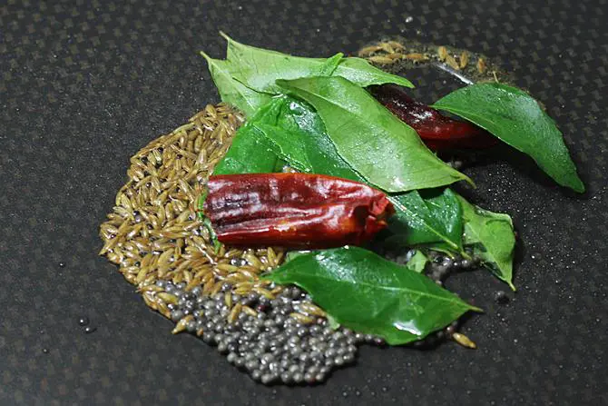 seasoning with tadka spices to make lemon rasam recipe