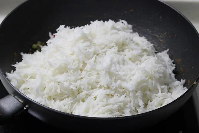 addition of cooked rice to pan to make capsicum pulao