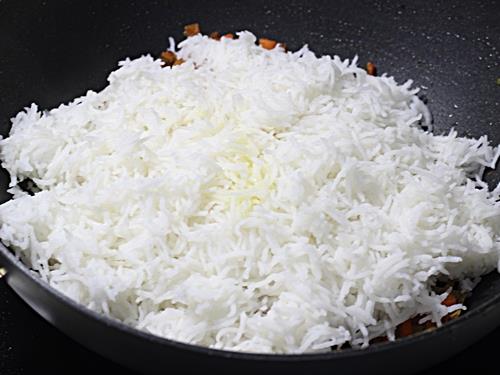 adding cooled rice in carrot rice recipe