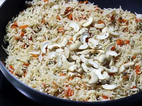 mixing ingredients with rice in carrot rice