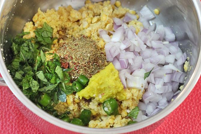 adding onions chilies herbs to make masala vada