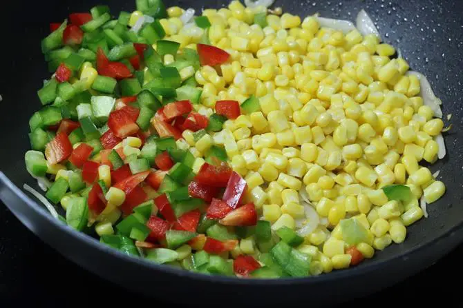 addition of veggies to the pan to make sweet corn fried rice