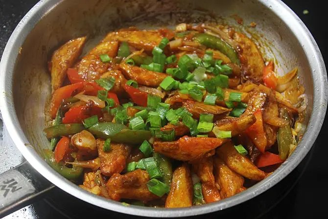 sauteing chilli potato with spring onions