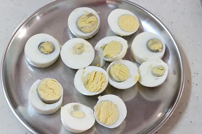 slicing boiled eggs to make egg pakora recipe