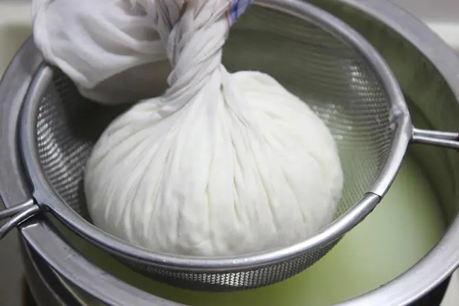 draining whey from paneer to make malai modak