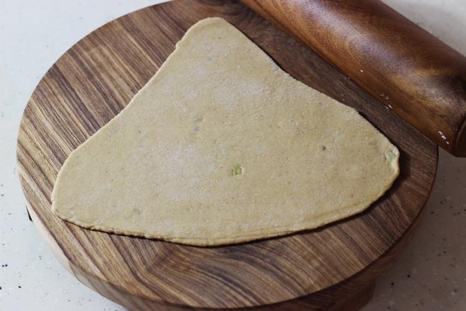 rolling the dough to make dal paratha