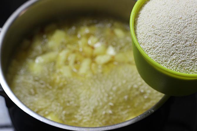 pouring sooji to boiling syrup