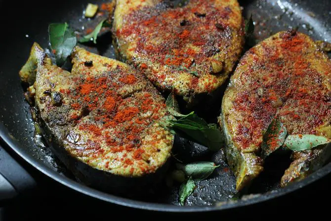 Add ghee to a hot pan, Add fish, curry leaves and begin to fry on a medium flame