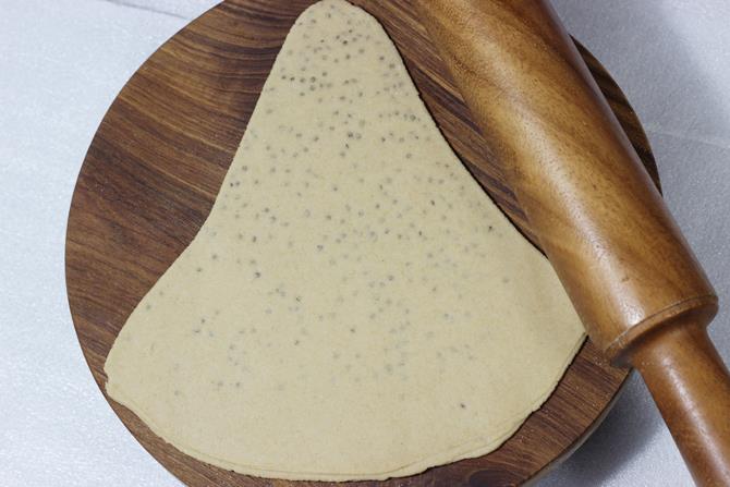 rolling dough to make ajwain paratha
