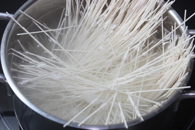 adding noodles to boiling water
